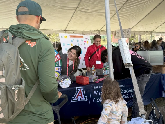 A family engaged in the spin-the-wheel climate and health trivia game.