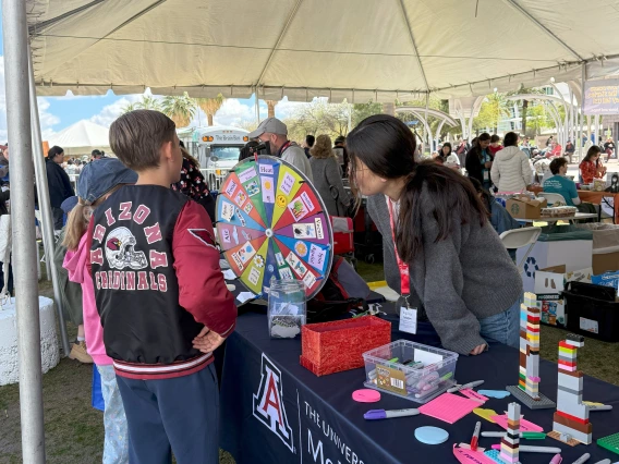 Festival goers playing a climate and health spin-the-wheel trivia game.
