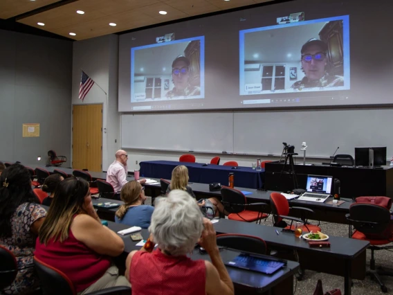 Photo of attendees watching Jason Glaser introduce the film "Too Hot to Work"