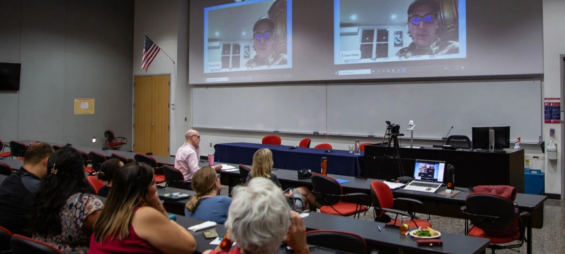 Photo of attendees watching Jason Glaser introduce the film "Too Hot to Work"