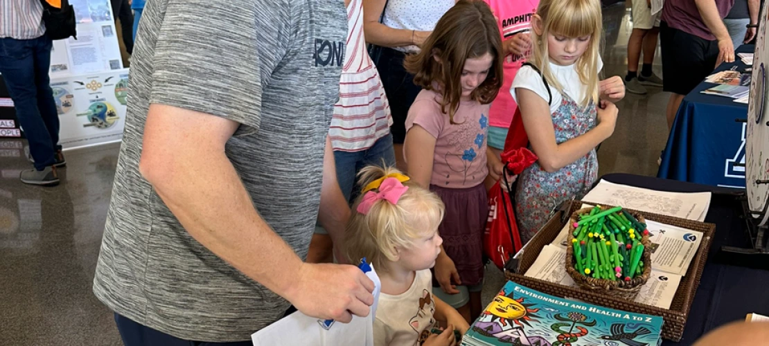 Dad with young daughter at the SCORCH Wellness and Wonder table.