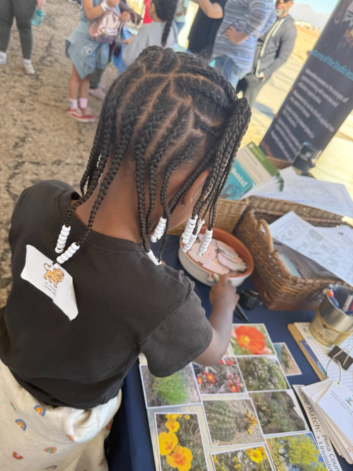 A DMAFB STEAM Village student attendee selecting a sticker prize for her participation in the climate and health spin-the-wheel trivia game.