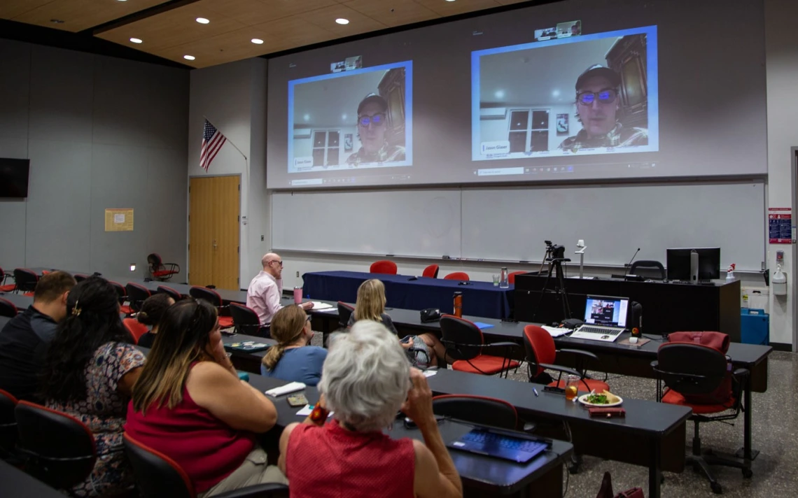 Photo of attendees watching Jason Glaser introduce the film "Too Hot to Work"