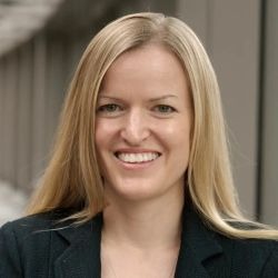 Photograph of Kate Ellingson. She has long blonde hair and is wearing a black colored jacket.
